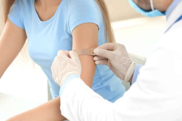 Doctor vaccinating young woman in clinic Woman getting flu shot